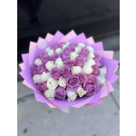 Bouquet of pink, purple, and white roses wrapped in pink paper