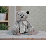 Gray plush teddy bear with a tag sitting on a table