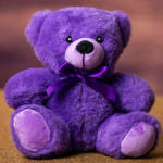 Purple teddy bear with a satin ribbon bow