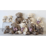 Assorted teddy bears with bows arranged on the floor and wire stands