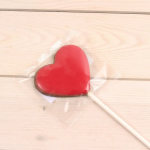 Red heart-shaped lollipop wrapped in clear plastic
