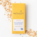 Yellow chocolate bar package with toffee pieces scattered around it