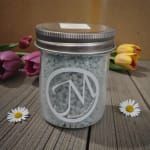 Glass jar with white beads, surrounded by tulips and daisies