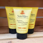 Three tubes of hand repair cream on a wooden surface
