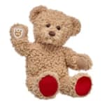 Plush teddy bear with red paw pads on a white background