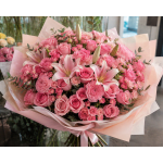 Large pink bouquet of roses, lilies, and carnations wrapped in pale paper