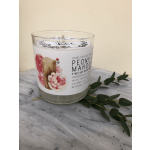Glass candle jar labeled Peony Mahogany with floral artwork