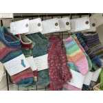 Colorful hand-knit socks hanging on a display rack