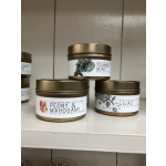 Three scented candles in gold tins labeled peony, mint, and lilac