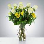White roses and yellow alstroemeria in a clear glass vase