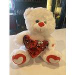 White teddy bear holding a red sequined heart