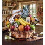 Fruit and snack basket with pineapple, bananas, apples, cookies, tea, and jam