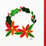 Quilled paper floral wreath with red, orange, and green flowers on a white background