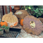 Pumpkins and decorative bamboo serving trays displayed with small potted succulents.