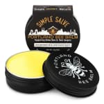 Two tins of Portland Bee Balm skin balm with black lids and yellow balm