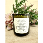 Green glass pineapple and sage candle with decorative foliage behind it