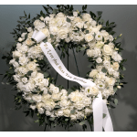 White floral wreath with a condolence ribbon