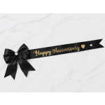 Black anniversary ribbon with a bow and gold lettering on a white surface