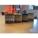 Four labeled bars of handmade soap on a wooden table