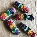 Four colorful flower bundles wrapped in paper on a brown surface