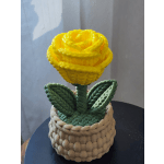 Yellow rose in a woven basket-style container with green leaves
