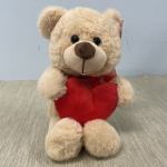 Plush teddy bear holding a red heart
