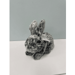 Small gray plush rabbit sitting on a white surface