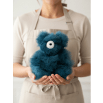Person holding a small blue teddy bear plush