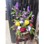 Mixed bouquet with yellow and red roses, white daisies, and purple flowers in a vase