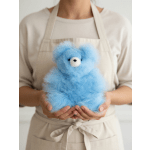 Person holding a small blue teddy bear