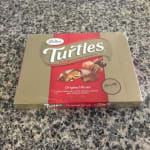 Box of Turtles caramel pecan chocolates on a countertop