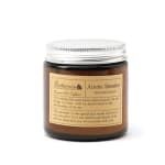 Brown scented candle in a glass jar with a silver lid