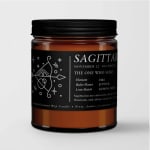 Amber candle in a black-lidded jar with a Sagittarius label