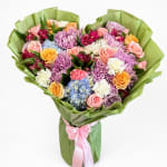 Mixed bouquet of roses, chrysanthemums, hydrangeas, and carnations wrapped in green paper