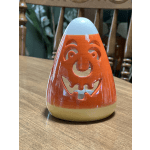 Candy corn-shaped ceramic candle holder on a wooden table