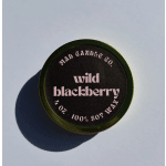 Round candle tin labeled wild blackberry on a light surface