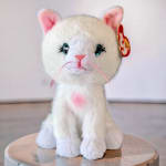 White plush cat toy with pink ears and whiskers