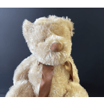 Cream-colored teddy bear with a brown satin ribbon