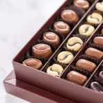 Box of assorted chocolates in brown paper cups