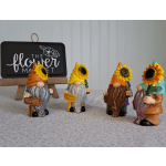Four small gnome figurines holding sunflowers and welcome signs