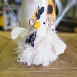 Small plush chicken figurine on a wooden surface