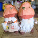 Two small fabric gnome figurines with orange hats and white beards