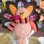 Plush turkey decoration with a striped scarf and felt wings