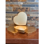 Gold heart-shaped boxes stacked on a stone surface