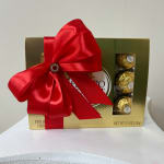 Box of chocolates wrapped with a large red ribbon and bow
