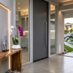 Potted orchids with white and purple blooms on a wooden table by a modern doorway