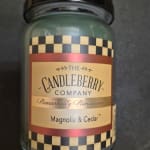 Glass candle jar labeled Magnolia & Cedar