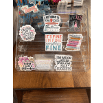 Clear acrylic display rack holding assorted decorative stickers and decals