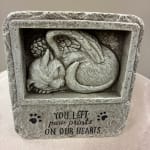 Stone memorial with a sleeping cat relief and paw prints