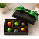 Box of assorted chocolates with a green ribbon on a marble surface